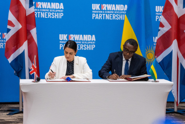 British home secretary Priti Patel (left) and Rwandan foreign minister Vincent Biruta (right) enacting the policy on 14 April 2022